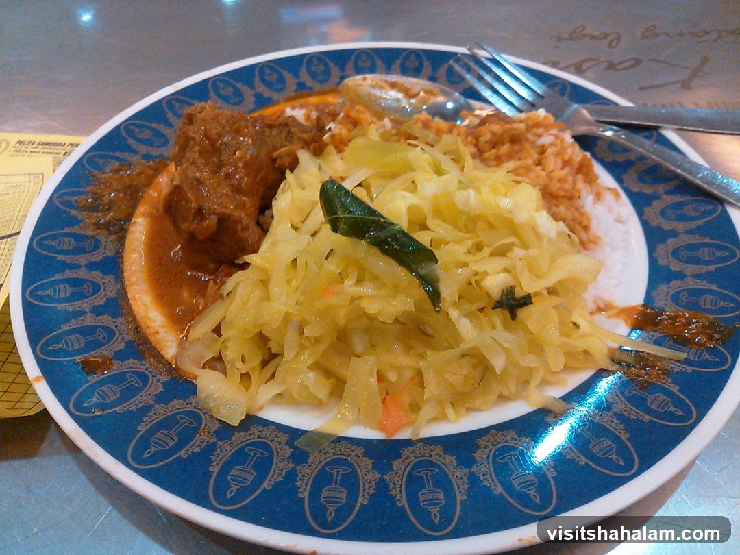 Plate of food with meat, rice, and cabbage