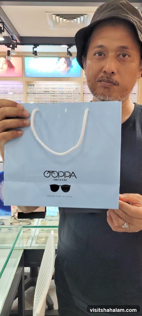 Man holding a shopping bag with glasses logo