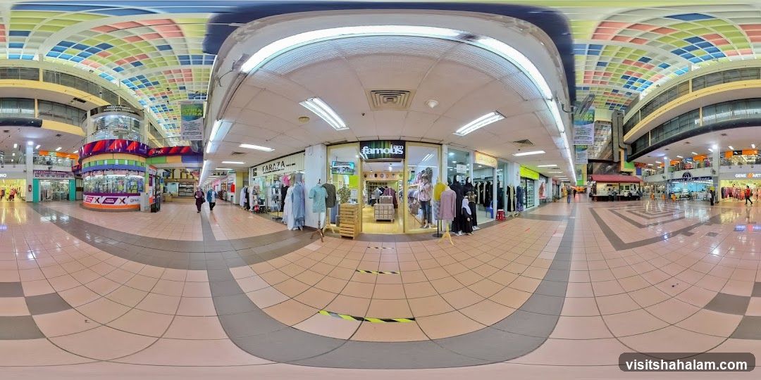 Indoor shopping mall with various stores and colorful ceiling