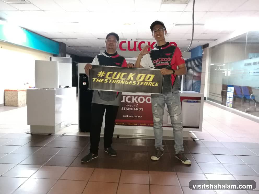 Two men holding a CUCKOO sign