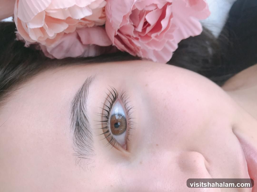Close-up of a woman's eye with a pink flower accessory
