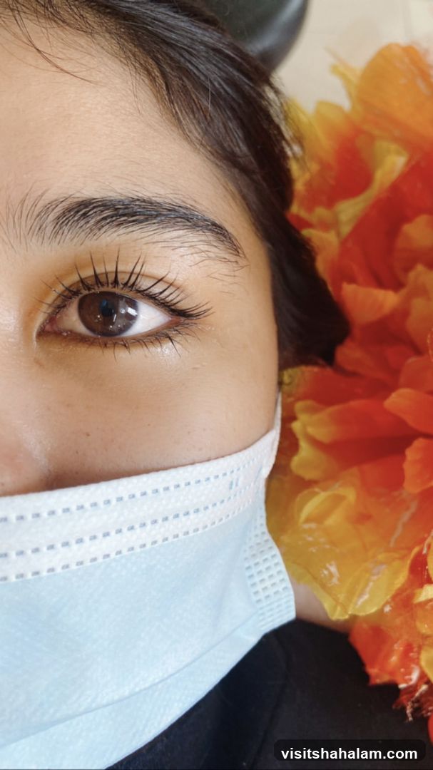 Close-up of a person's eye with a face mask and floral decoration