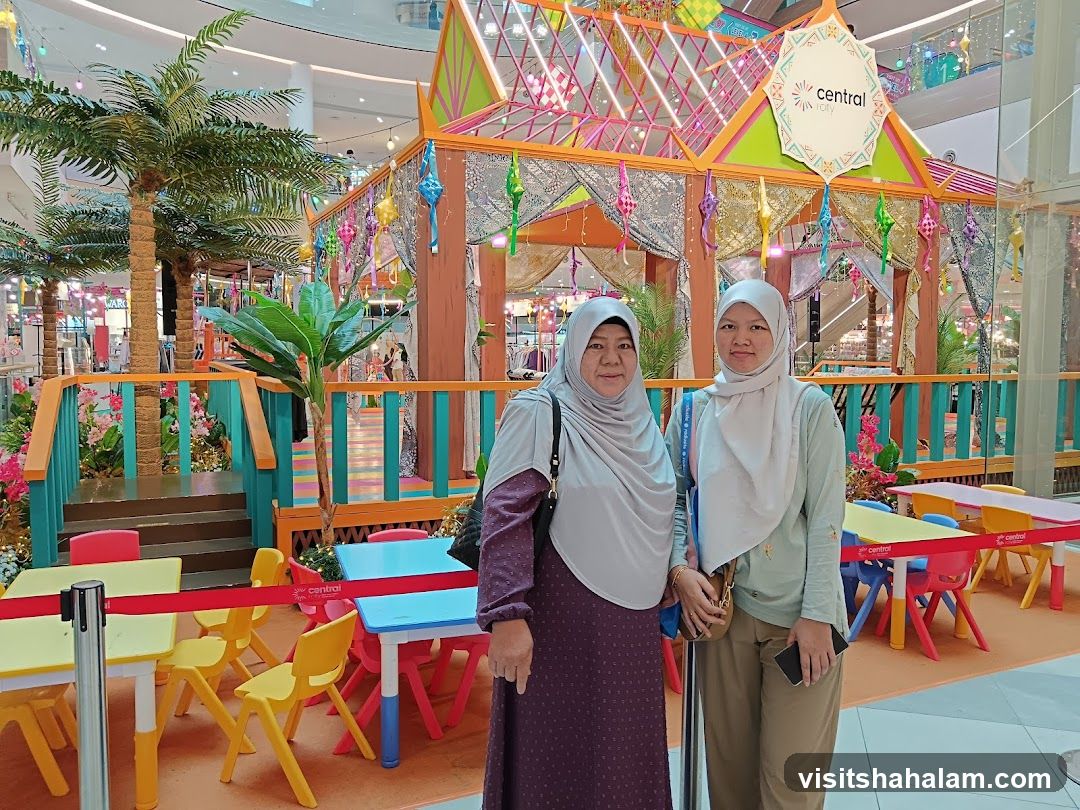 Two women posing in front of a festive display