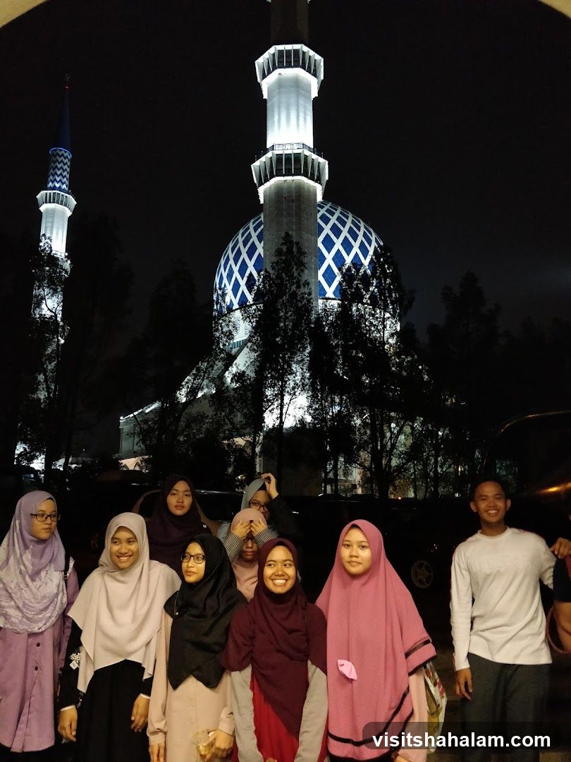 Group of people in front of a mosque at night