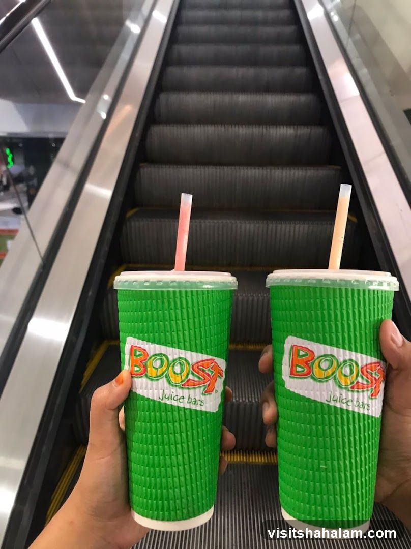 Two Boost Juice Cups on Escalator