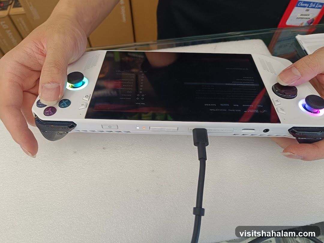 Hand holding a white gaming handheld device