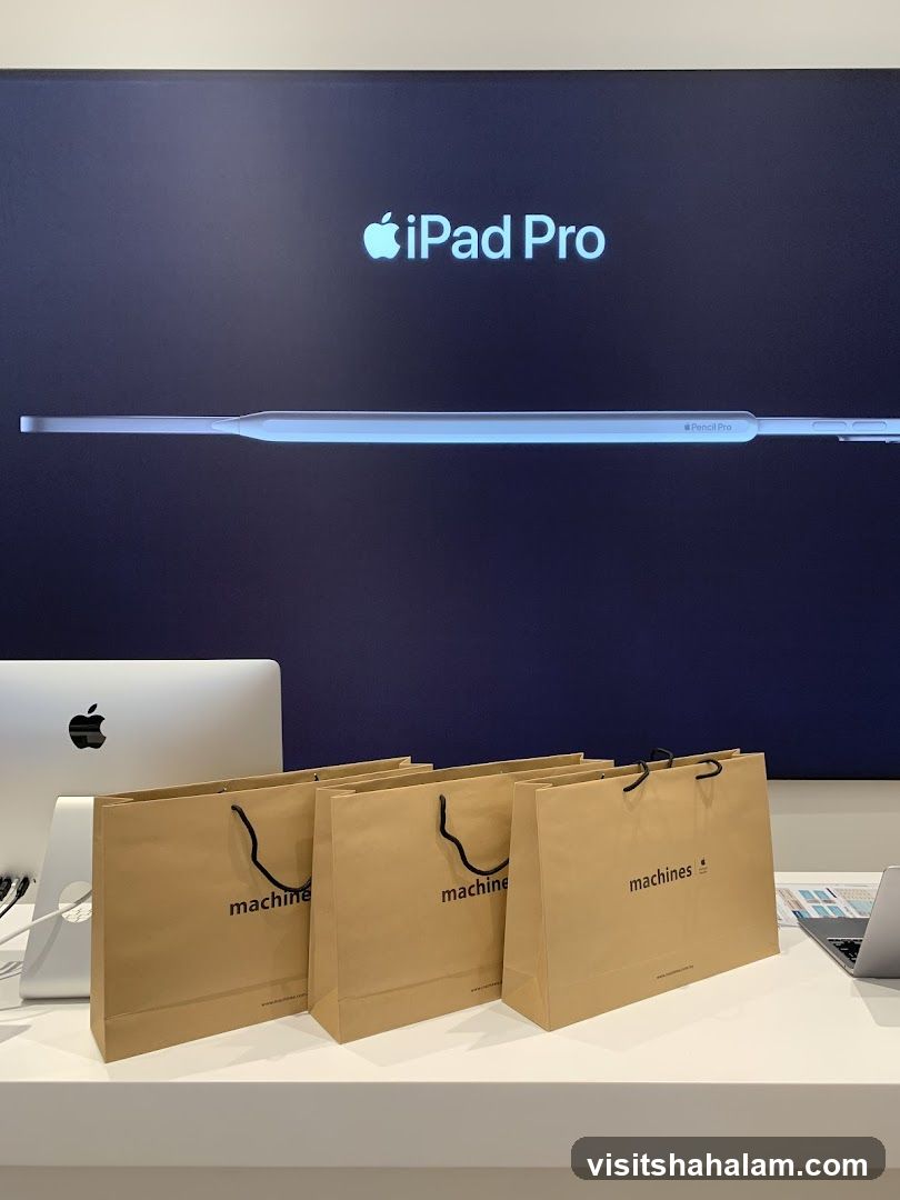 Apple iPad Pro and Pencil Pro display with branded shopping bags
