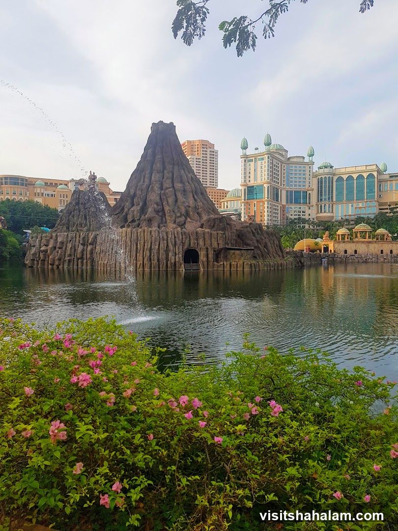 Volcano-themed attraction with a lake and buildings