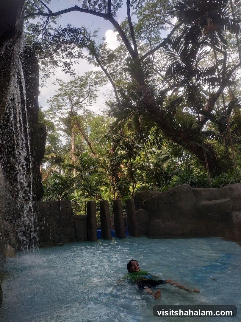 Boy relaxing in a pool with a waterfall