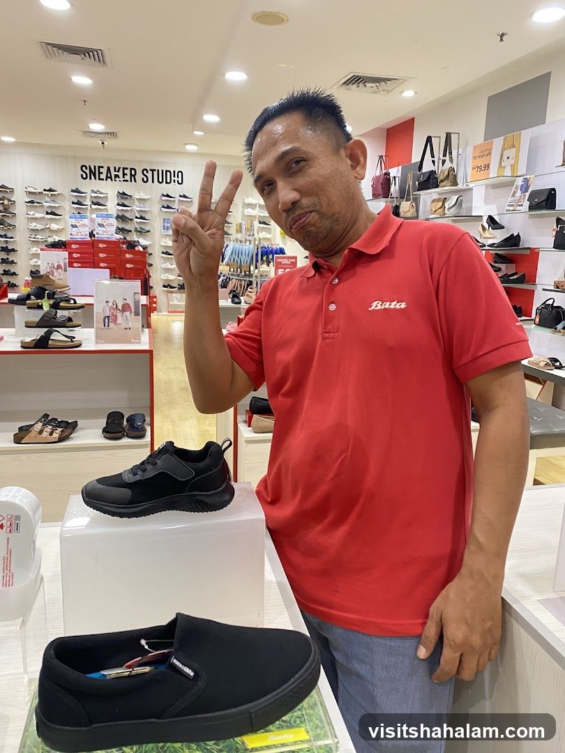 Man in a Red Bata Polo Shirt Posing in a Shoe Store