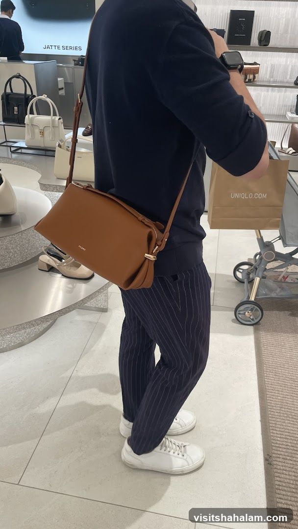 Person carrying a brown handbag in a store