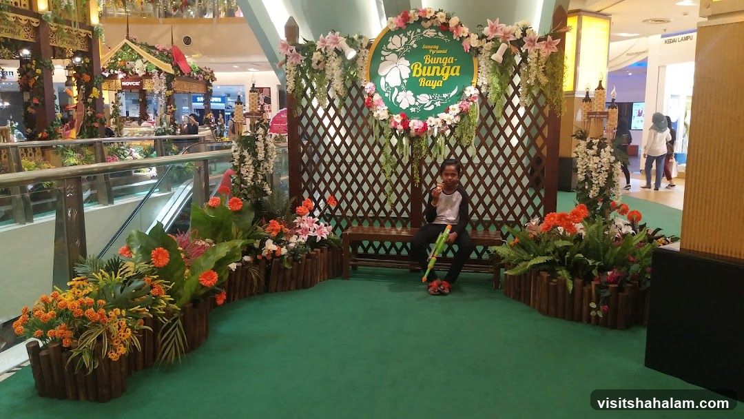 Decorative floral display with a child sitting on a bench