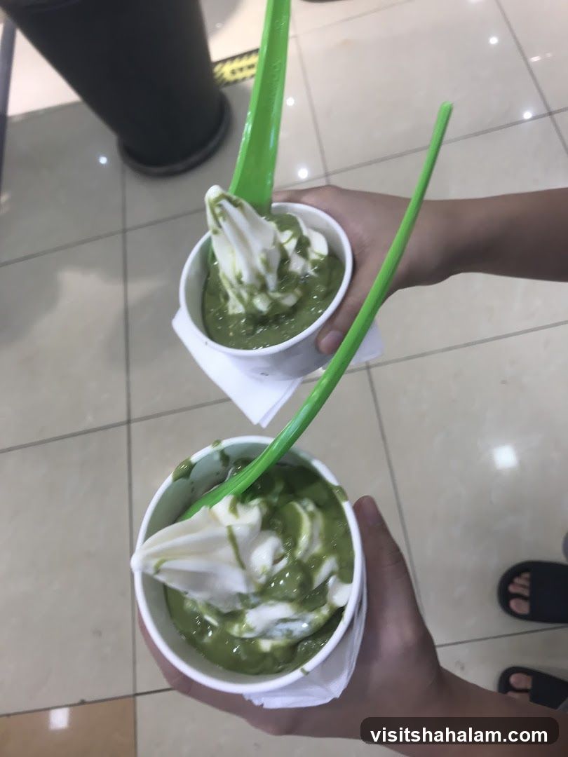 Two cups of soft serve ice cream with green topping