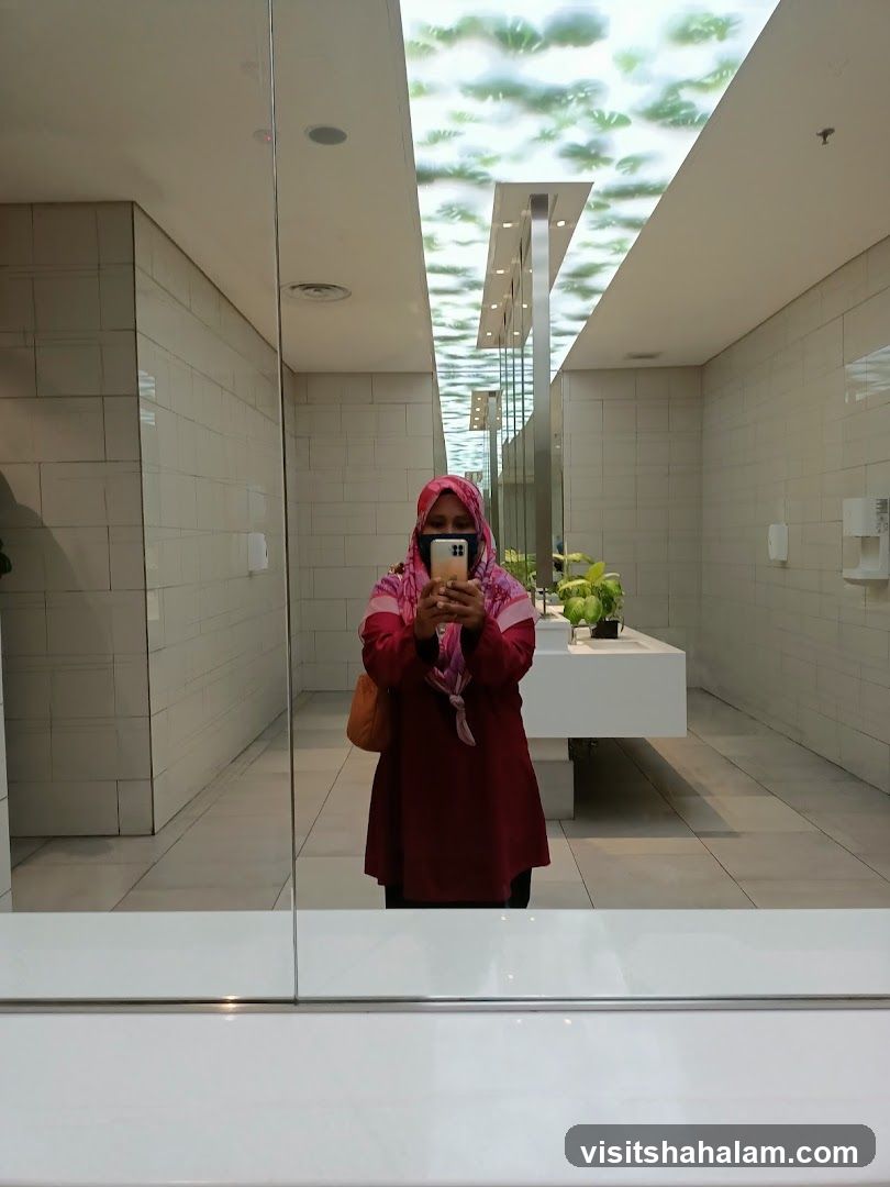 Woman taking a mirror selfie in a modern restroom