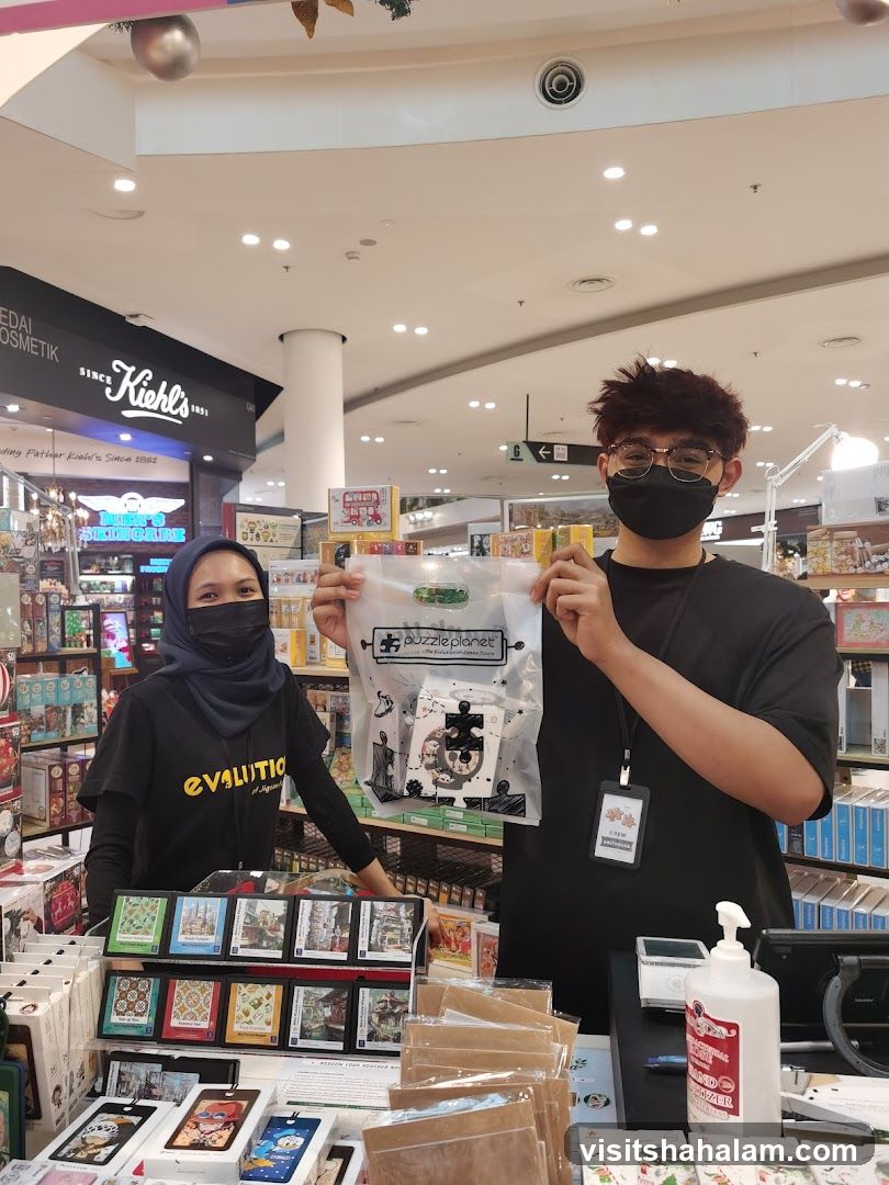Staff holding a Puzzle Planet bag
