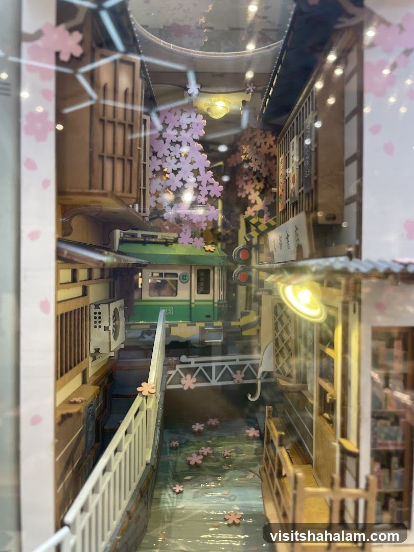 Diorama of a Japanese street scene with a train and cherry blossoms