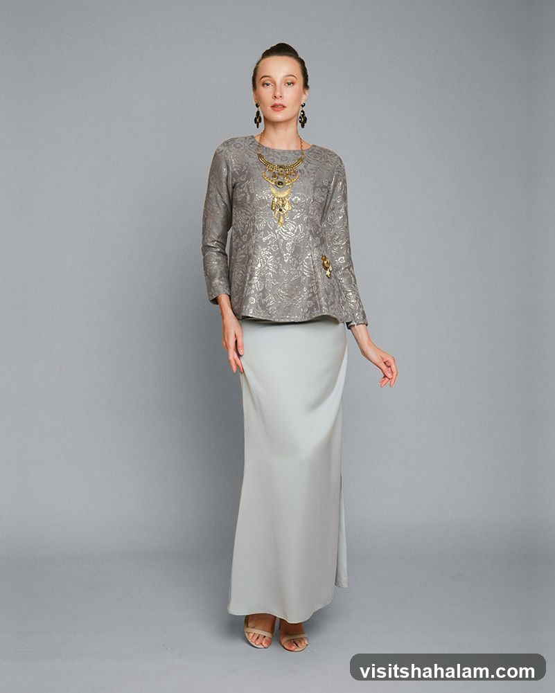 Woman in grey patterned top and long grey skirt