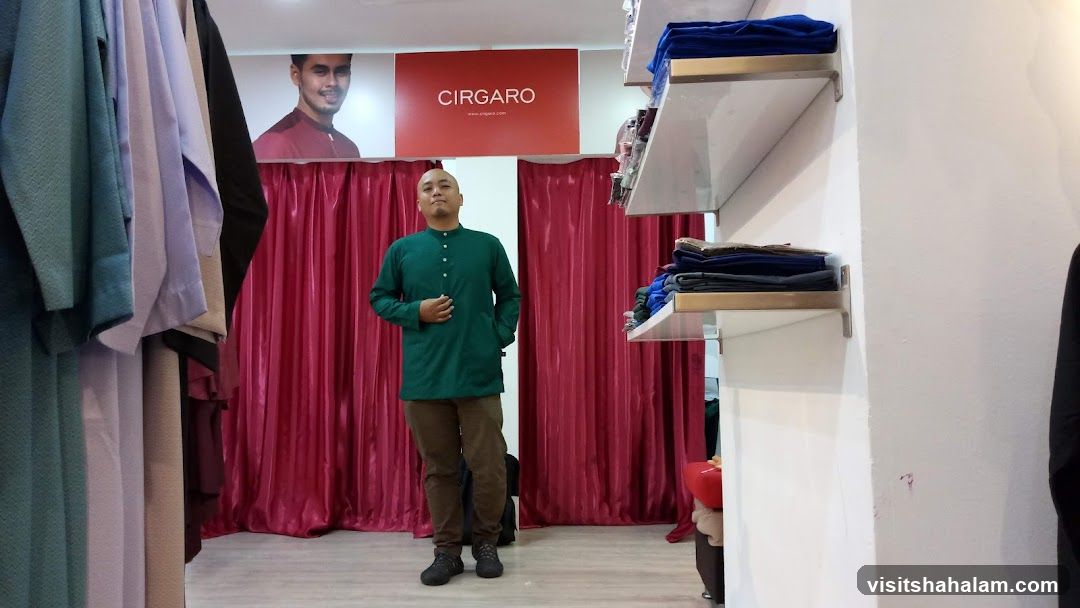 Man in a store trying on a green shirt