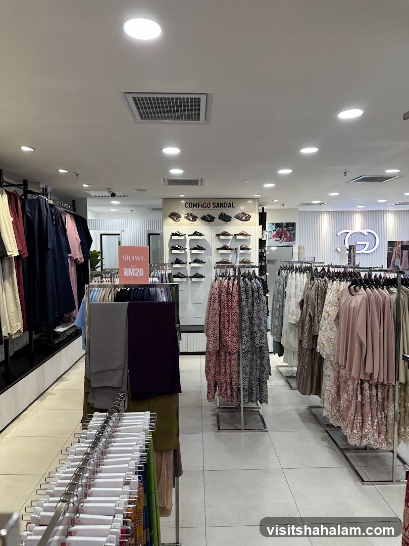 Clothing store interior with racks of apparel and footwear display.