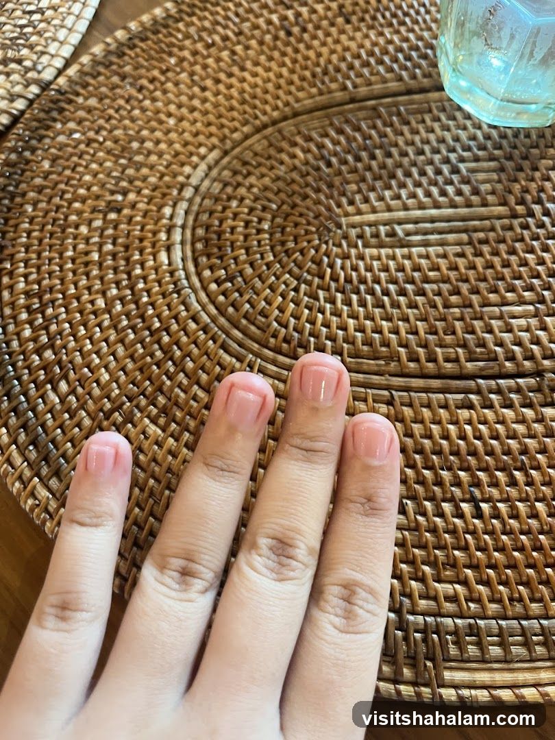 Hand with manicured nails on a woven placemat