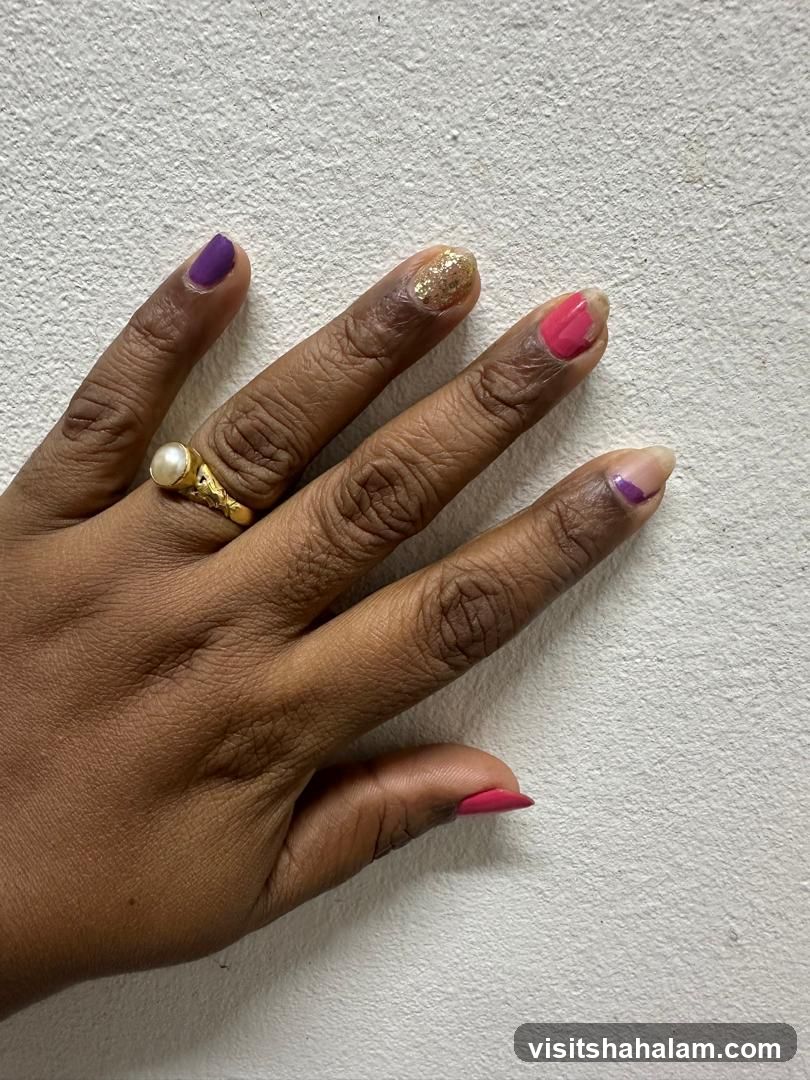 Hand with colorful nail polish and a ring
