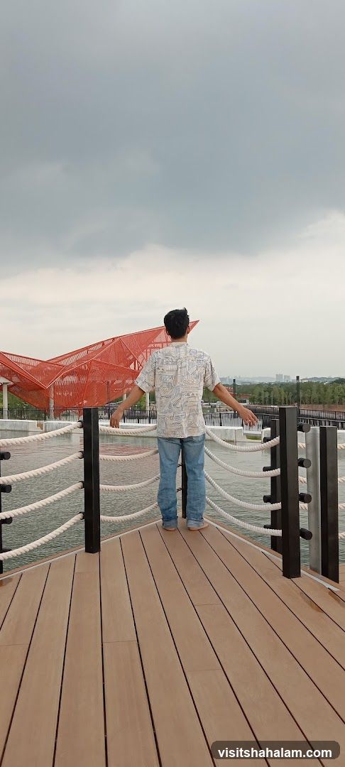 Man on a Boardwalk Overlooking Water