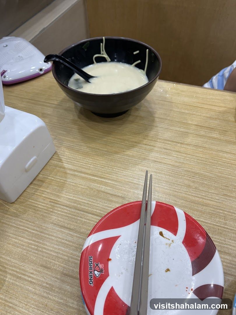 Bowl of noodles with soup and chopsticks on a plate