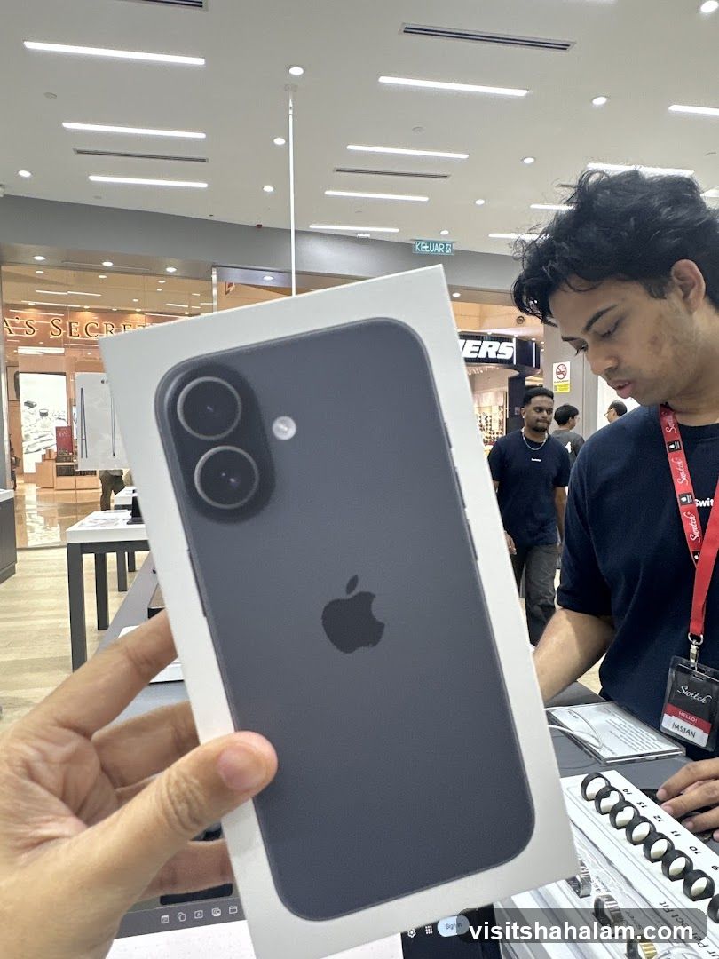 Person holding an iPhone box in a store