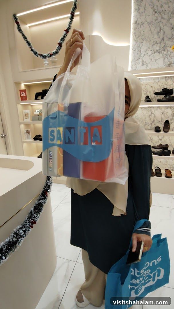 Woman holding shopping bag with "SANTA" logo