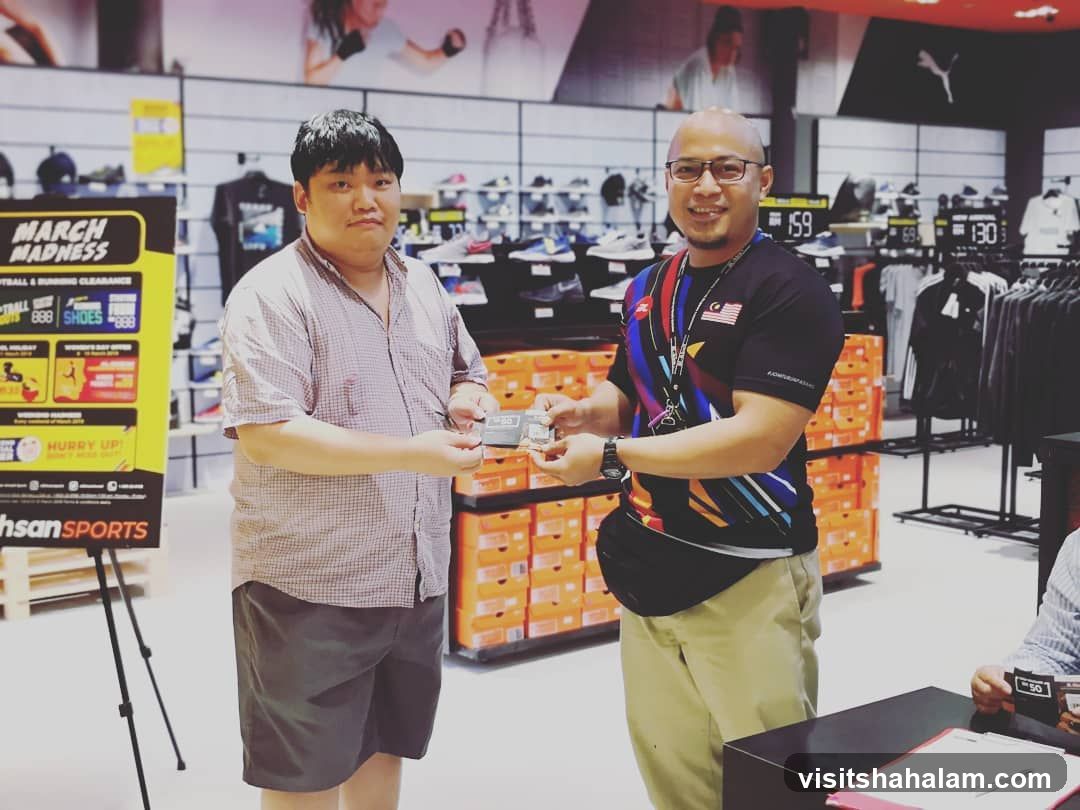 Two men exchanging items in a sports store