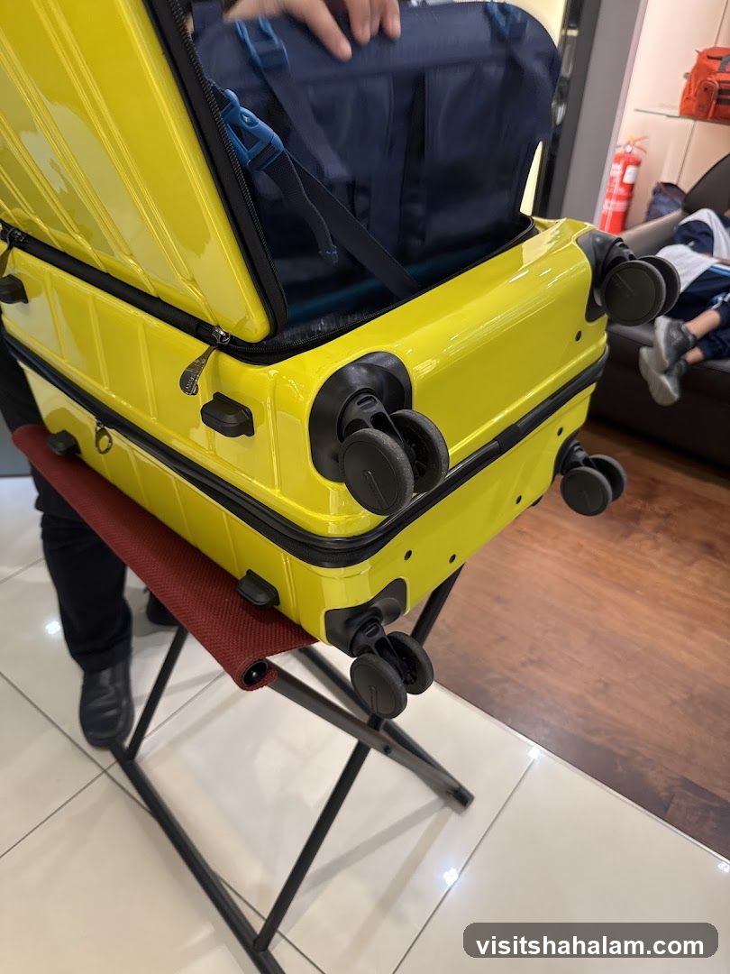 Bright yellow suitcase with a navy blue duffel bag inside
