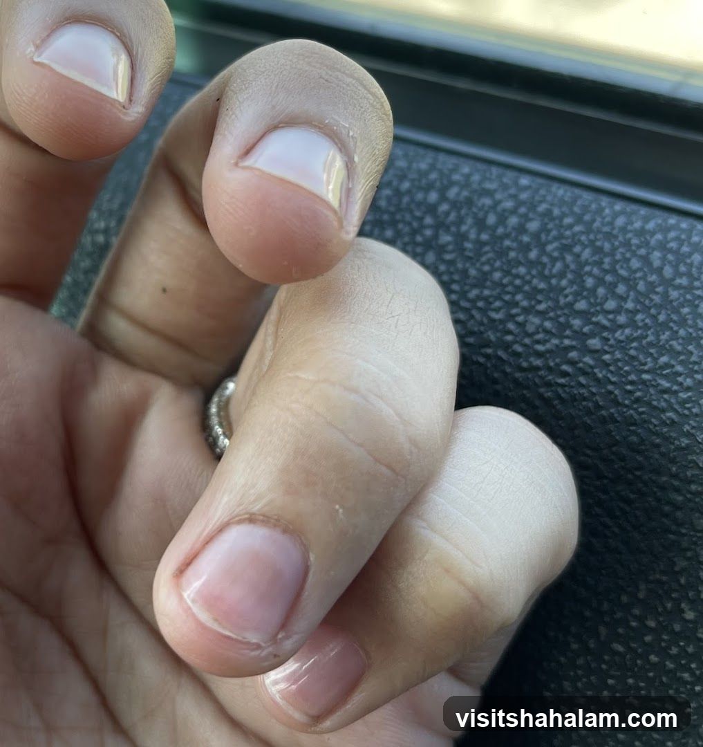 Close-up of a hand with light pink nail polish
