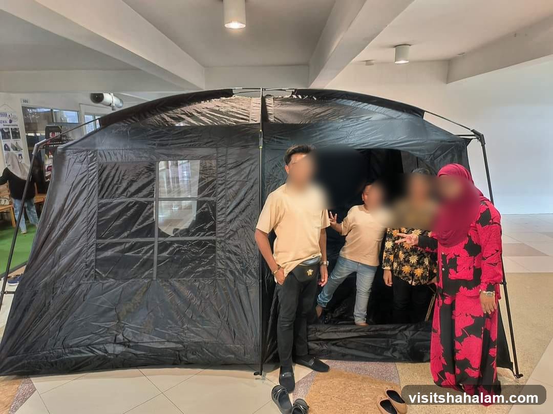 People posing in front of a large black tent