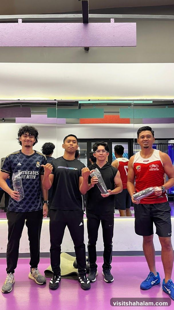 Four men posing in a gym