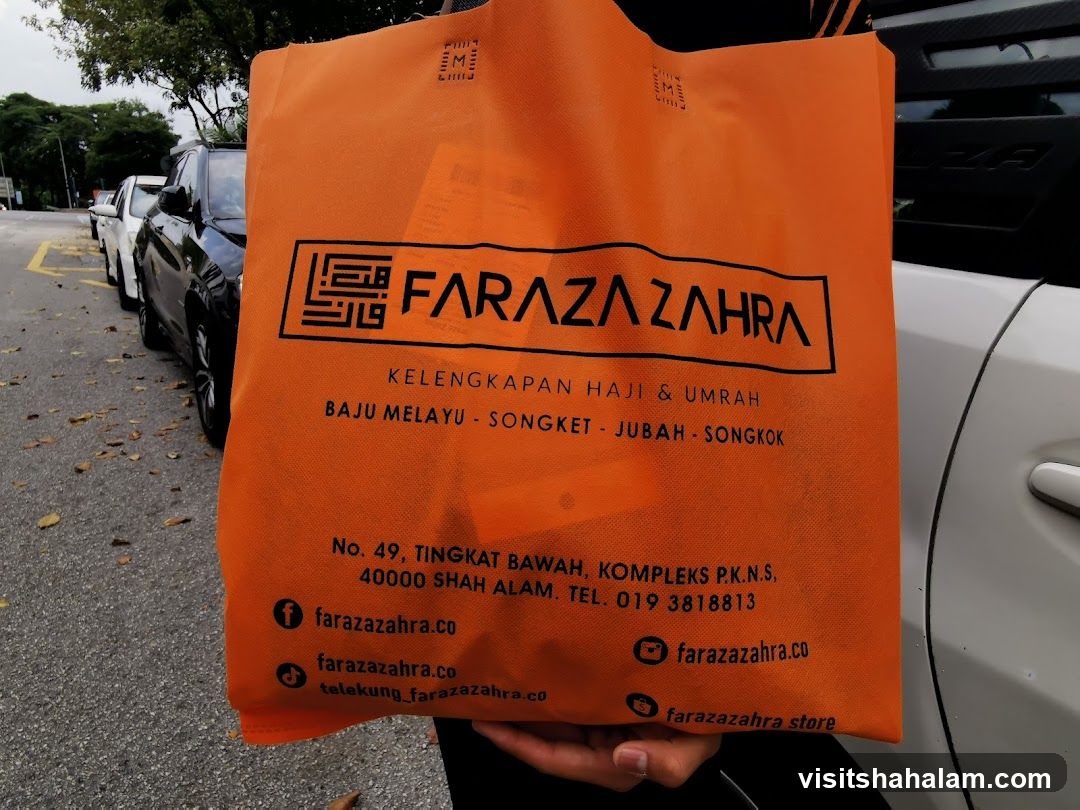 Orange tote bag with brand logo and contact information