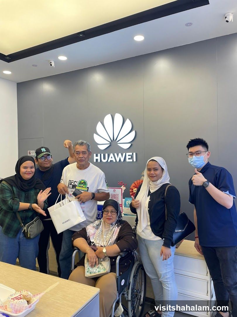 Group Poses in Front of Huawei Logo