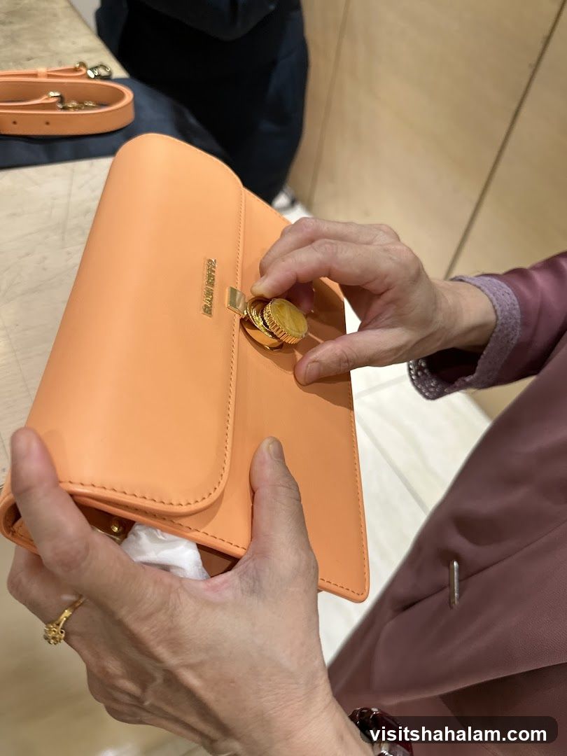 Person holding an orange clutch bag