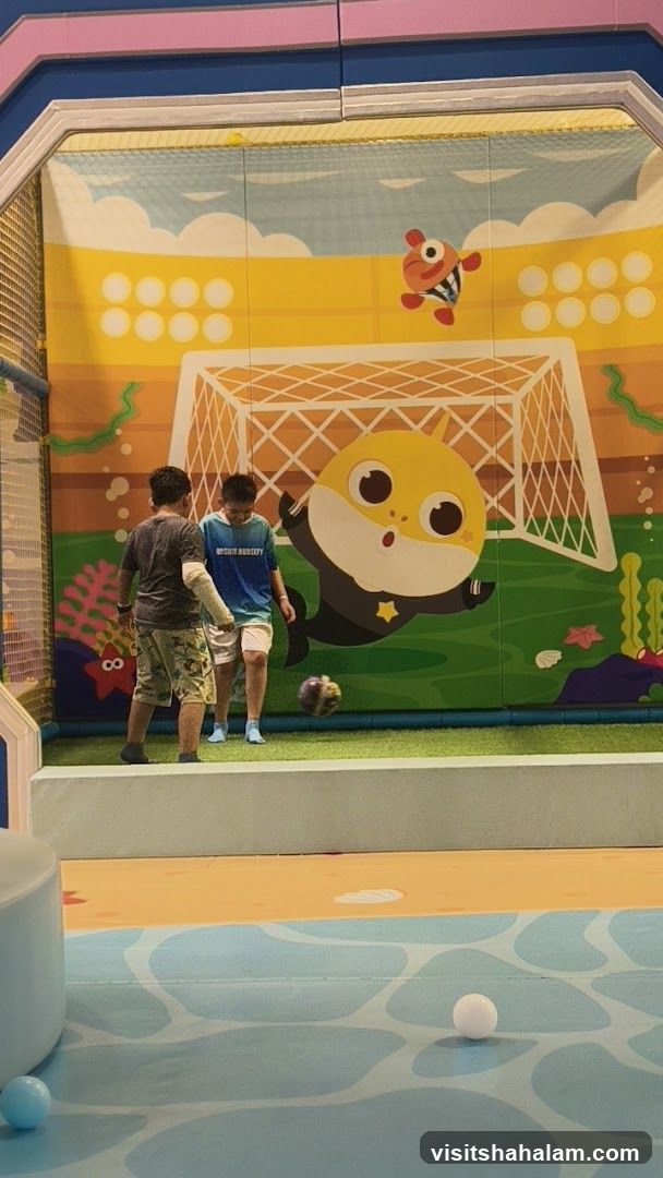 Children playing soccer in a cartoon-themed indoor playground