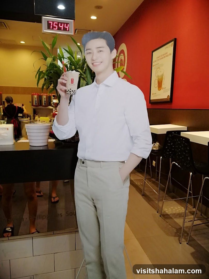 Cardboard cutout of a man holding a bubble tea