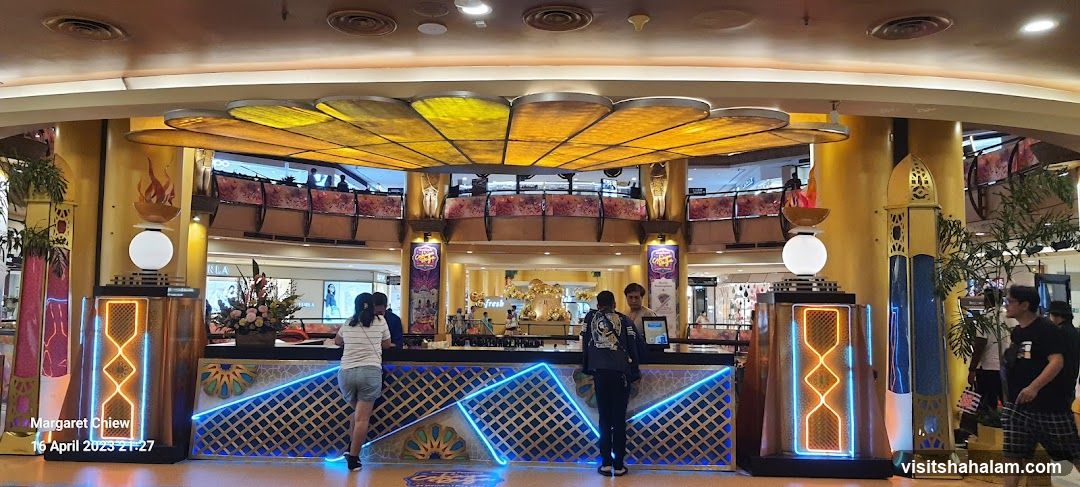 Interior of a brightly lit shopping mall with a decorative counter