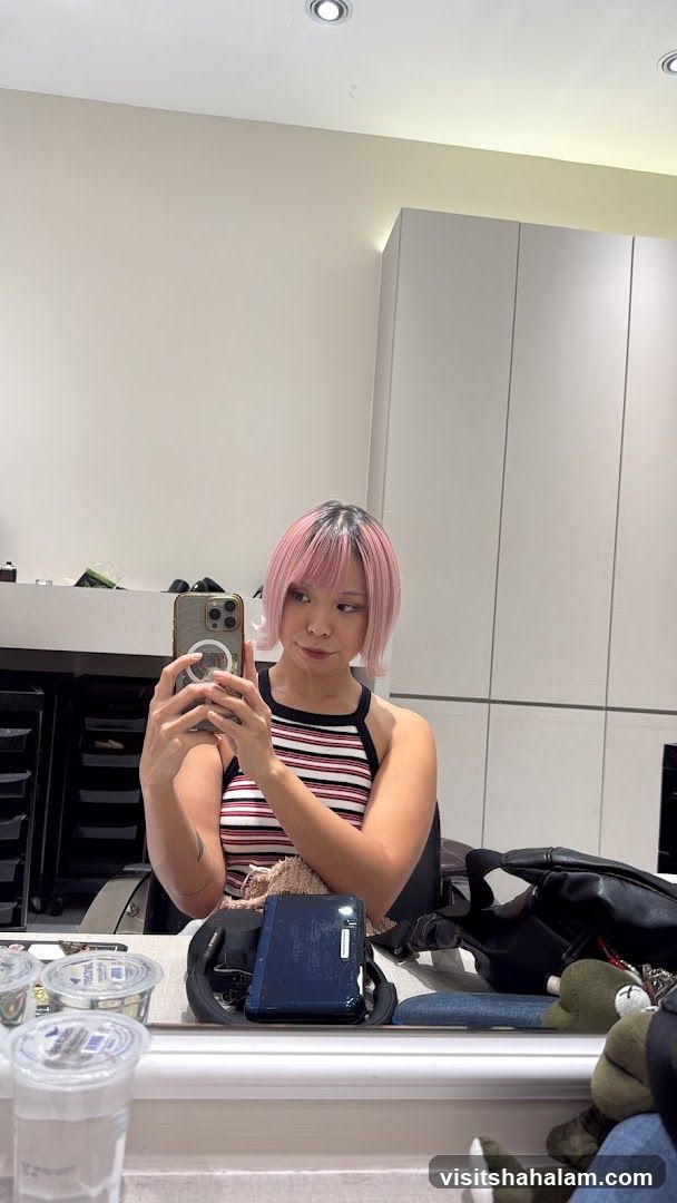 Woman taking a mirror selfie with pink hair