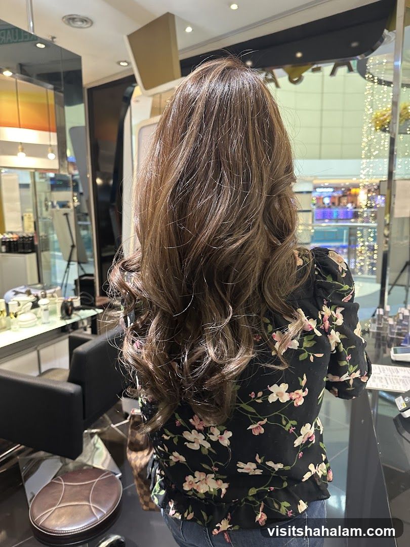 Woman with long, wavy brown hair in a salon