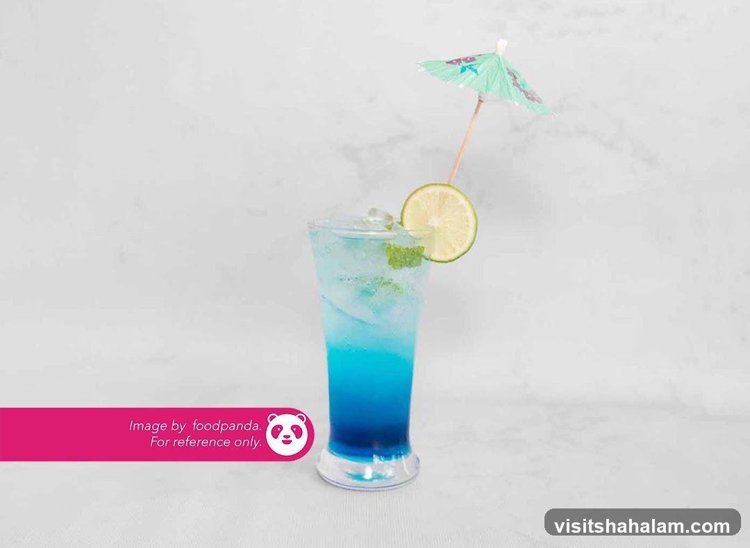 Blue layered drink with lime and umbrella