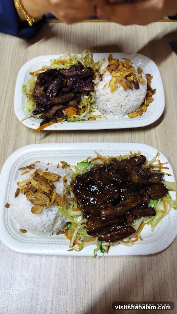 Two plates of rice with meat and vegetables