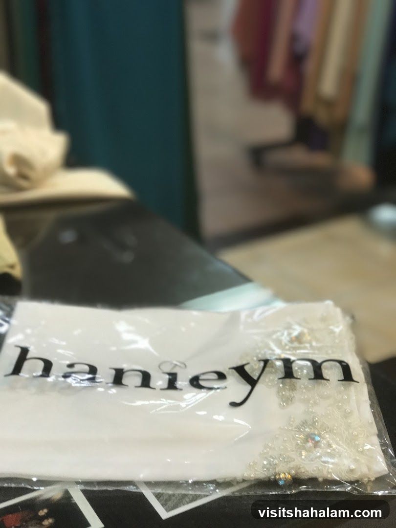 White garment with beaded trim and logo