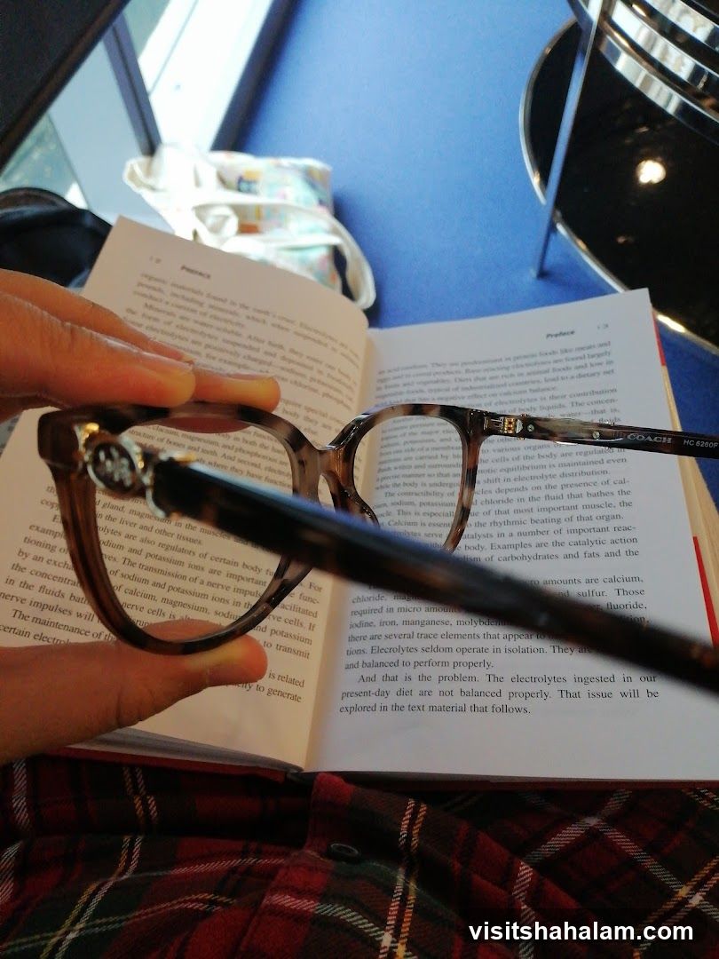 Person reading a book with glasses