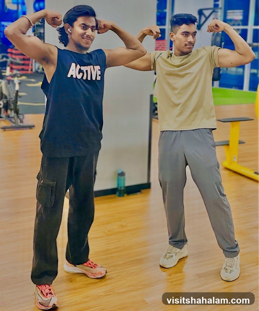 Two men flexing muscles in a gym
