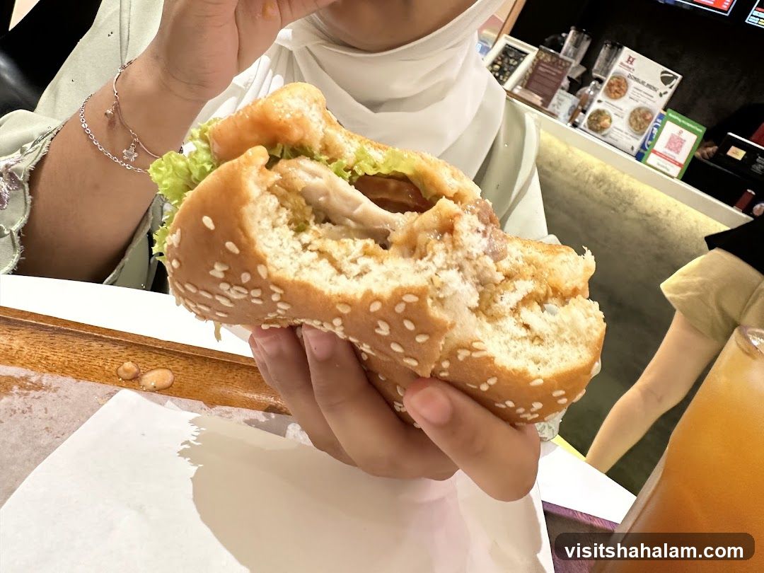 Person holding a half-eaten burger