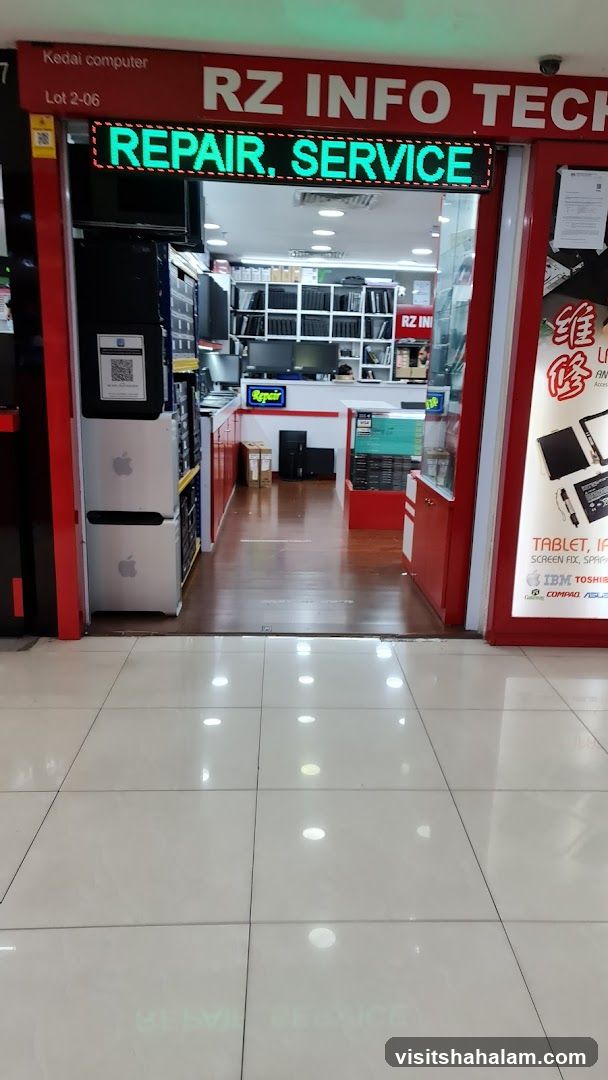 The exterior of a computer repair shop. A red facade with a digital sign above the entrance displaying "REPAIR, SERVICE" in green LED lights. Inside, shelves are stocked with laptops and computer parts.