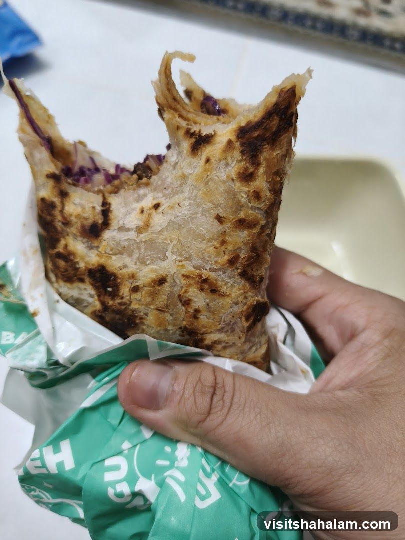 Hand holding a partially eaten wrap